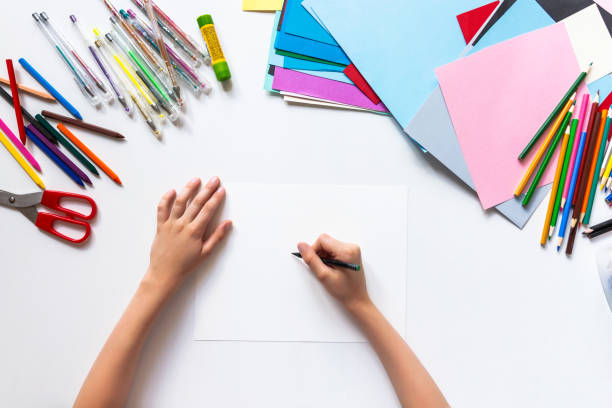 istock Top view. Unrecognizable child drawing on white paper. Copy space 1266299455