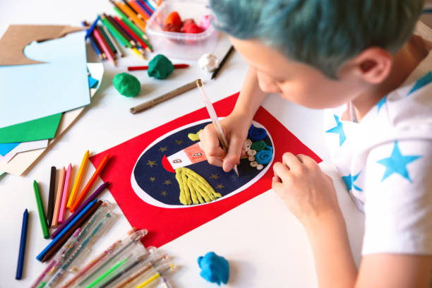 istock Child doing creative hand made work with color paper and plasticine. Kids crafts. 1266299458