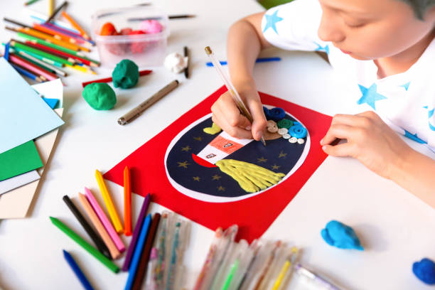 istock Child doing creative hand made work with color paper and plasticine. Kids crafts. 1266299469