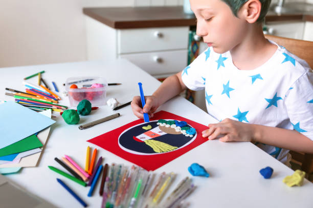 istock Child doing creative hand made work with color paper and plasticine. Kids crafts. 1266299491