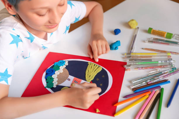 istock Child doing creative hand made work with color paper and plasticine. Kids crafts. 1266299494