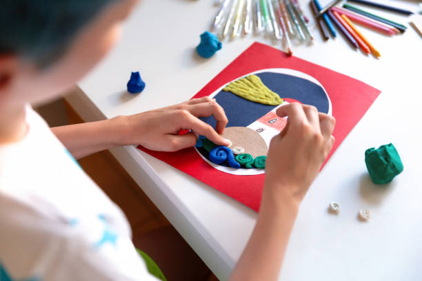 istock Child doing creative hand made work with color paper and plasticine. Kids crafts. 1266299501