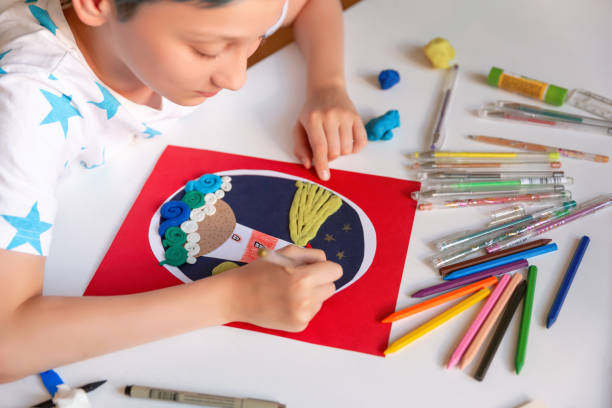 istock Child doing creative hand made work with color paper and plasticine. Kids crafts. 1266299502