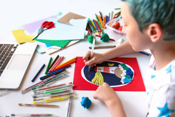 istock Child doing creative hand made work with color paper and plasticine. Kids crafts. 1266299523