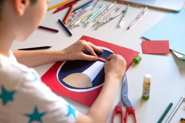 istock Boy doing art homework project with color paper. Top view. 1266299571