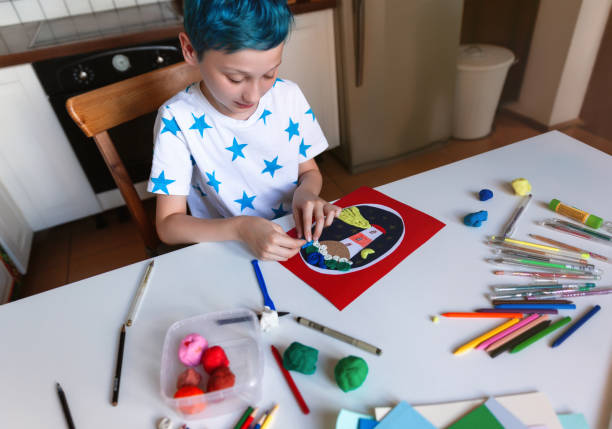 istock Child doing creative hand made work with color paper and plasticine. Kids crafts. 1266300342