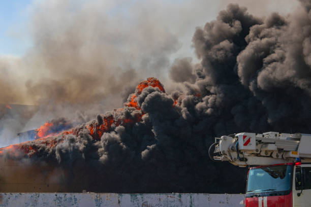 istock Flame and black smoke from a burning building. Fire truck. Firefighting 1266300619