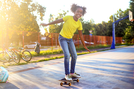 Girl having fun with a skateboard. About 10 years old, African female.
