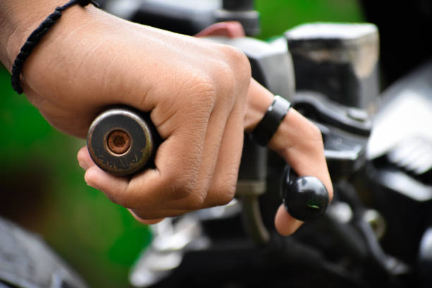 Human hand holding a bike handlebar and accelerating.