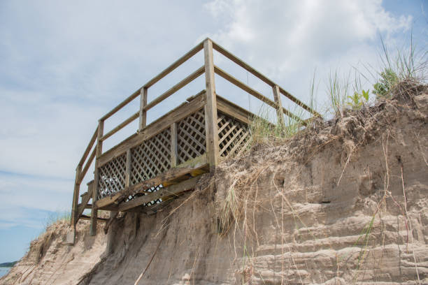Dune Steps: Danger Dangerous beach access stairs at edge of dune erosion from storm damage in Bridgman, Michigan eroded stock pictures, royalty-free photos & images