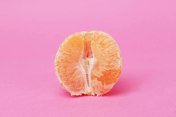 istock half orange without skin on pink background 1266306069