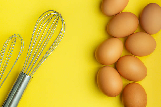 istock Chicken eggs, brown eggs, broken egg in carton box on yellow background. Top view natural eggs in carton box product concept 1266306134