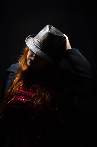 Retro man in hat wears suit and tie, red light. Noir style.