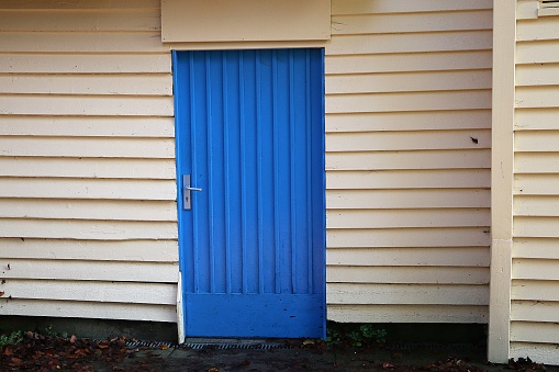 Closeup shot of a blue door on a white house