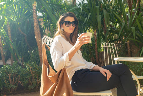 istock Beautiful brunette visiting tropical garden. Flirting with camera 1266311705