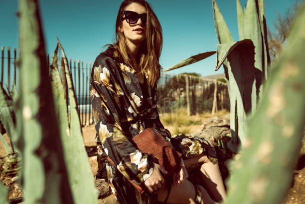 Stylish woman posing between succulents. Desert view