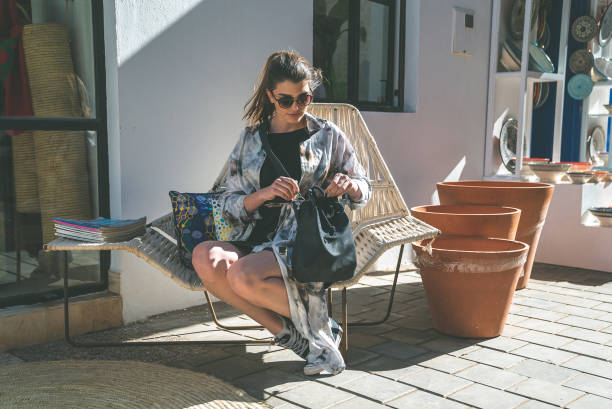 Moscow, Russia - August 2018: Young woman in clothes of the 19th century sitting with knitting in her hands during the Moscow historical festival Times and Epochs. Fashion in France during Napoleon