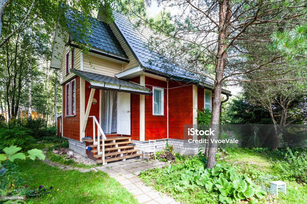 one-storey wooden country house with attic one-storey wooden country house with attic in Russia in summer Building Exterior Stock Photo