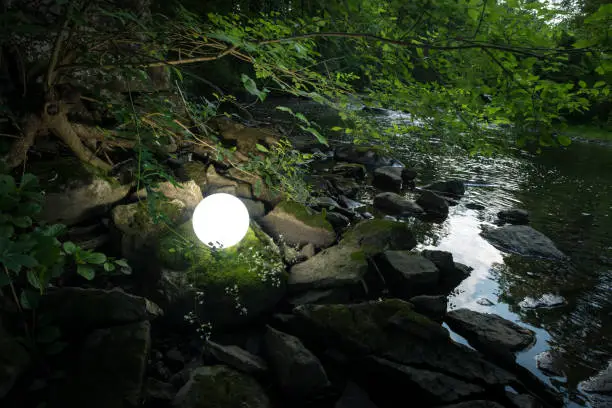 Bright glowing magic crystal ball in woods for fantasy imagery