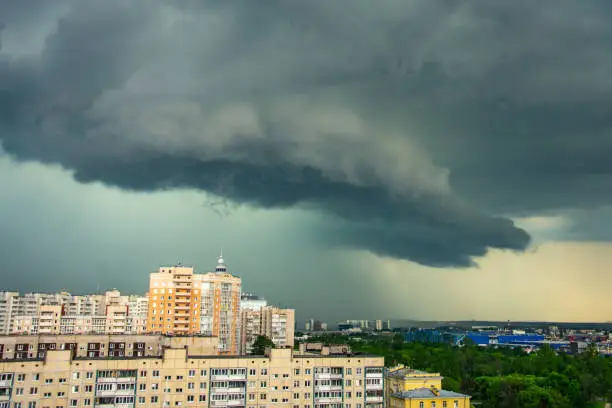 Stormy thunderclouds with heavy rain over multi-storey residential buildings in the city