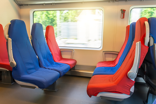 Six passenger seats in red and blue colors inside the high-speed train