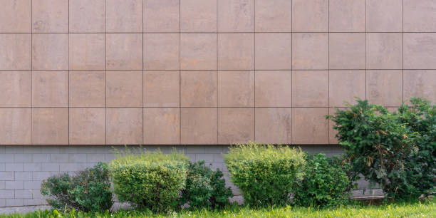 istock empty building gray wall with blank space over green hedge on greenery lawn 1266318382