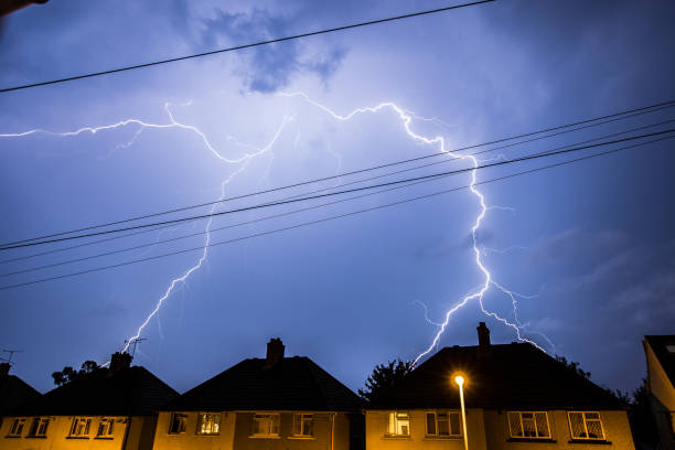 tormenta relámpago en el cielo nocturno por encima de las casas - lightning thunderstorm city storm fotografías e imágenes de stock