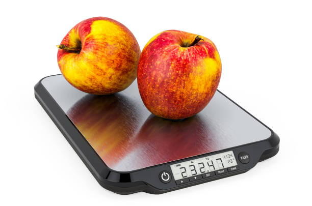 escalas de cocina con manzanas rojas. representación 3d aislada sobre fondo blanco - weight scale apple comparison balance fotografías e imágenes de stock
