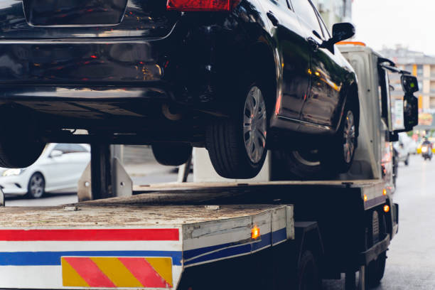 Black Broken Car on a Towing Truck. Closeup Photo. Vehicle Mechanical Problem or wrong parking on the Road. Tow Truck, Towing, Car, Parking, Parking Lot tow truck stock pictures, royalty-free photos & images