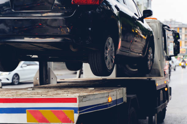 Black Broken Car on a Towing Truck. Closeup Photo. Vehicle Mechanical Problem or wrong parking on the Road. Tow Truck, Towing, Car, Parking, Parking Lot towing stock pictures, royalty-free photos & images