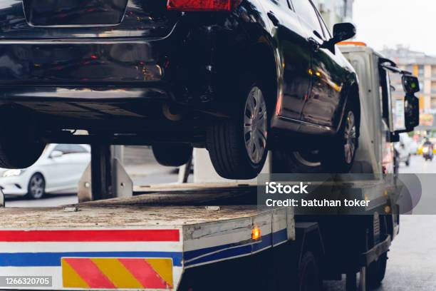 Black Broken Car On A Towing Truck Closeup Photo Vehicle Mechanical Problem Or Wrong Parking On The Road Stock Photo - Download Image Now