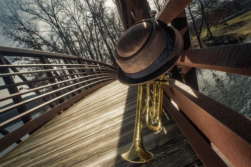 Old worn trumpet with pork pie hat on bridge