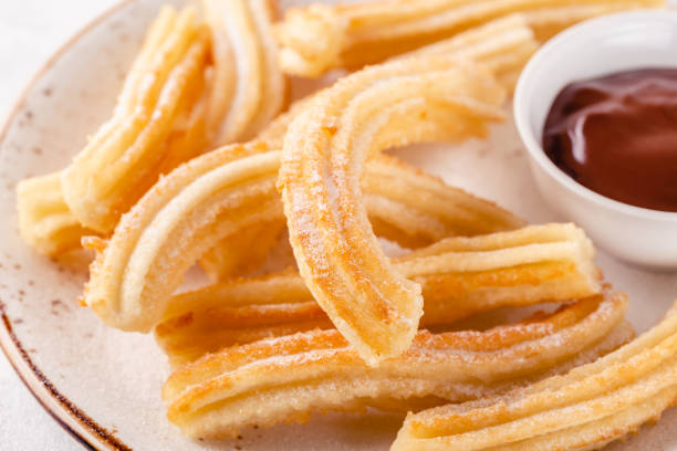 istock Churros with powdered sugar and chocolate sauce. 1266322683