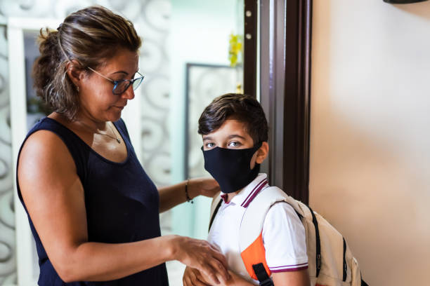 istock Mother helping son to put on mask before going to school during Covid-19 1266323655