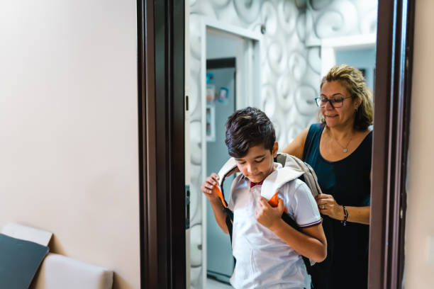 Mother sending off her elementary age Boy to school during Covid-19