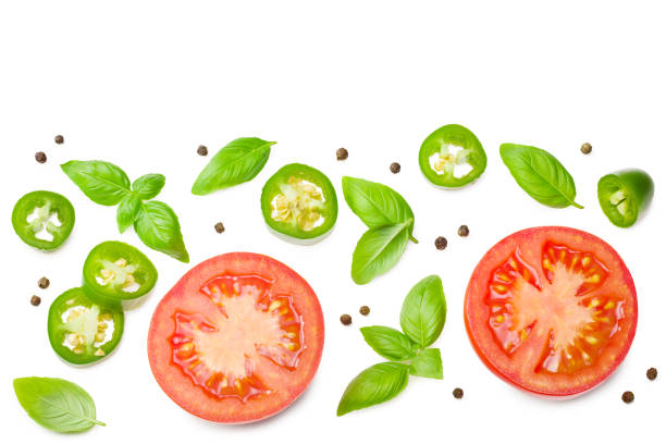 istock fresh tomato slices with green pepper and basil leaves isolated on white background. top view 1266325310