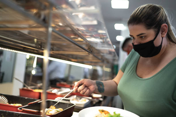 istock Customer picking up food in a self service restaurant using face mask 1266326394