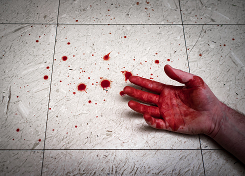 Crime scene murder victim hands with blood spatter on floor