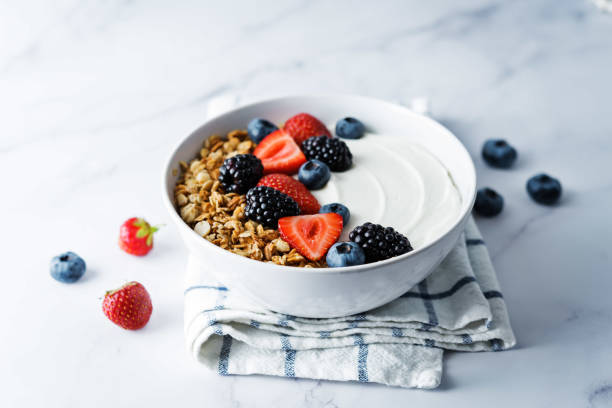 Fresh breakfast with greek yogurt nuts oatmeal granola with berries in a bowl Fresh breakfast with greek yogurt nuts oatmeal granola with berries in a bowl. the toning. selective focus greek yogurt photos stock pictures, royalty-free photos & images