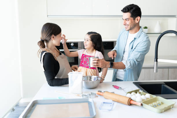 istock Parents Having Fun While Preparing Food With Daughter 1266328926