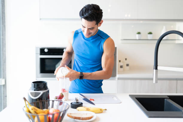 istock Hispanic Man Preparing Strawberry Milkshake 1266329943
