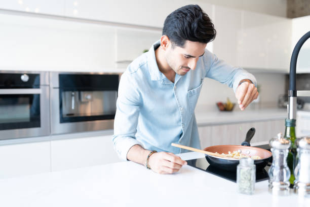 istock Latin Man Cooking Pasta In Kitchen 1266329993