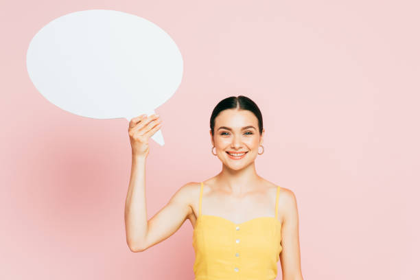 istock brunette young woman with white blank speech bubble on pink 1266331255