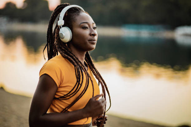 istock Athletic woman with headphones running 1266331466