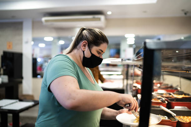 istock Customers in a self service restaurant choosing food using face mask 1266333457