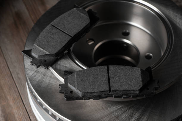 istock Close-up on brake pads and discs on wooden background 1266333537