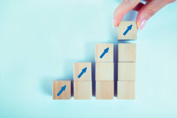istock Woman hand arranging wood block stacking 1266333605