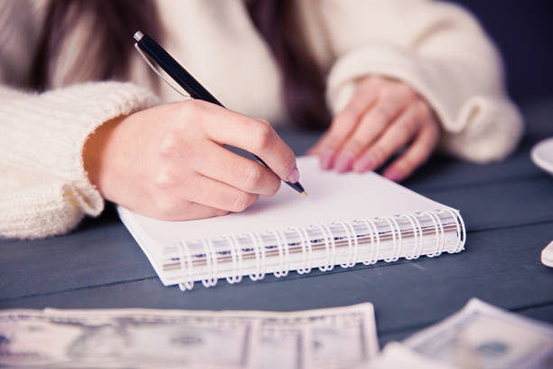 istock woman hand notepad with money 1266333700