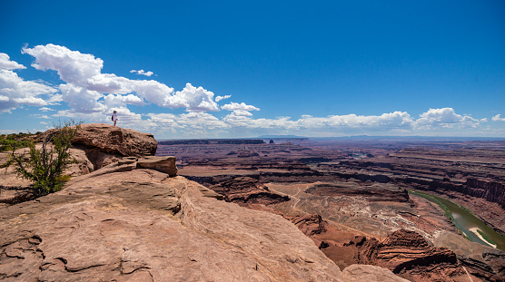 Dead Horse Point, Utah, USA - July 19, 2020: Panoramic view of Colorado river canyon from Dead Horse Point in Utah. La Sal Mountains are visible on the horizon.