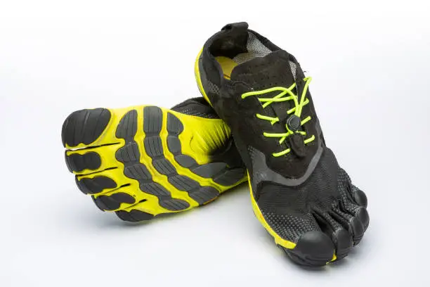 Pair of grey/yellow barefoot shoes, isolated with a white background